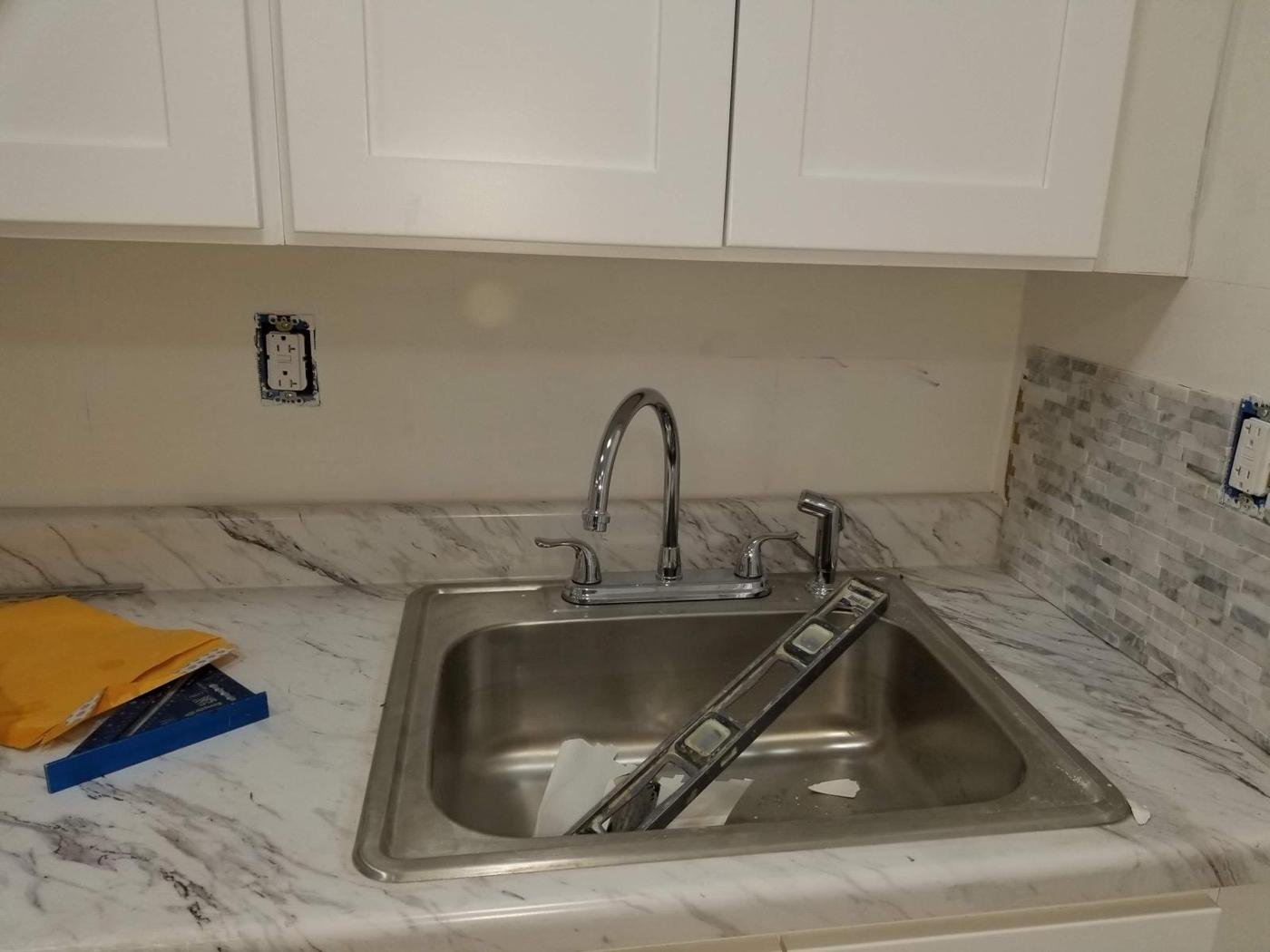 Kitchen remodel with white cabinets and marble-look counters by Tigre General Construction in Dutchess County